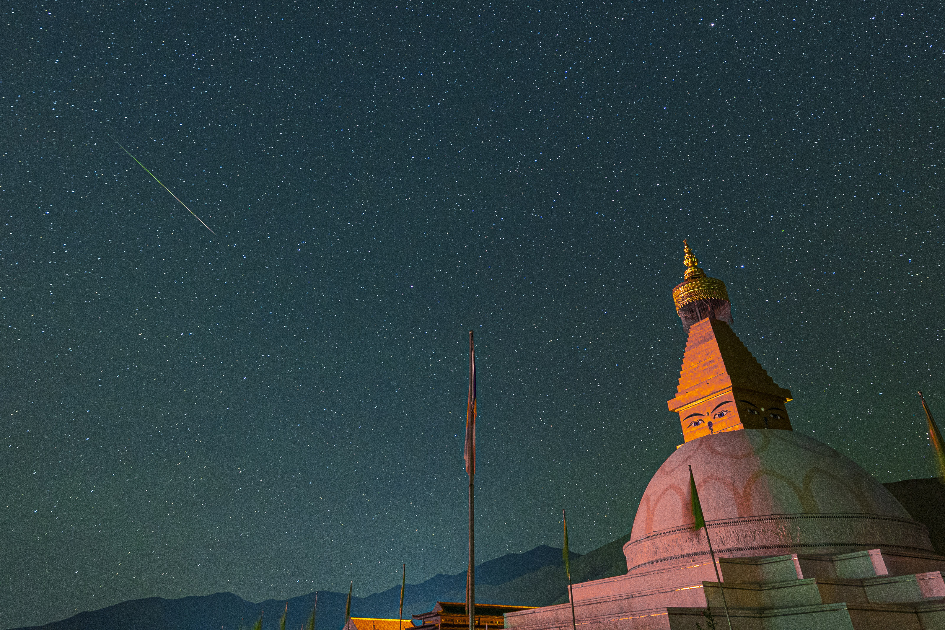 Un meteorito Perside cruza el cielo sobre un gran edificio abovedado.