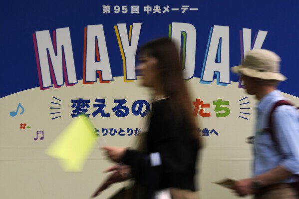 La gente camina hacia el lugar de una marcha del Día del Trabajo en Tokio, el miércoles 1 de mayo de 2024. (Foto AP/Hiro Komae)