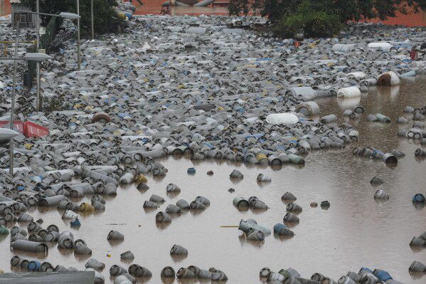 Cilindros de gas flotan en las aguas de una inundación en un centro de distribución de gas después de fuertes lluvias en Canoas, estado de Rio Grande do Sul, Brasil, el viernes 10 de mayo de 2024. (Foto AP/Andre Penner)