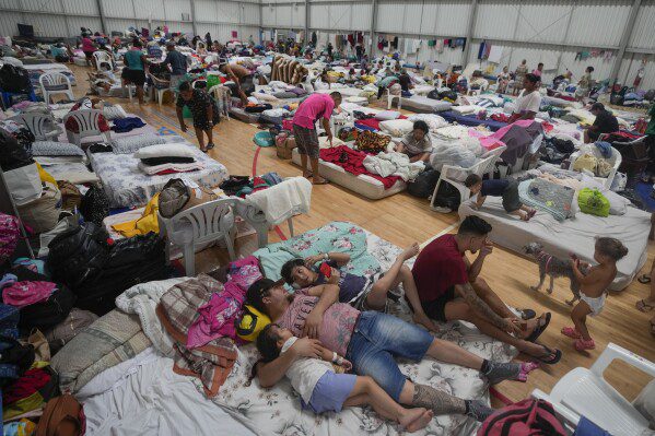Residentes descansan en un refugio temporal para personas cuyas casas quedaron inundadas por las fuertes lluvias, en Canoas, estado de Rio Grande do Sul, Brasil, el miércoles 8 de mayo de 2024. (Foto AP/Carlos Macedo)