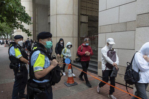 La gente hace cola frente a los Tribunales de Magistrados de West Kowloon en Hong Kong, el jueves 30 de mayo de 2024, antes de los fallos en un caso de seguridad nacional.  (Foto AP/Chan Long Hai)