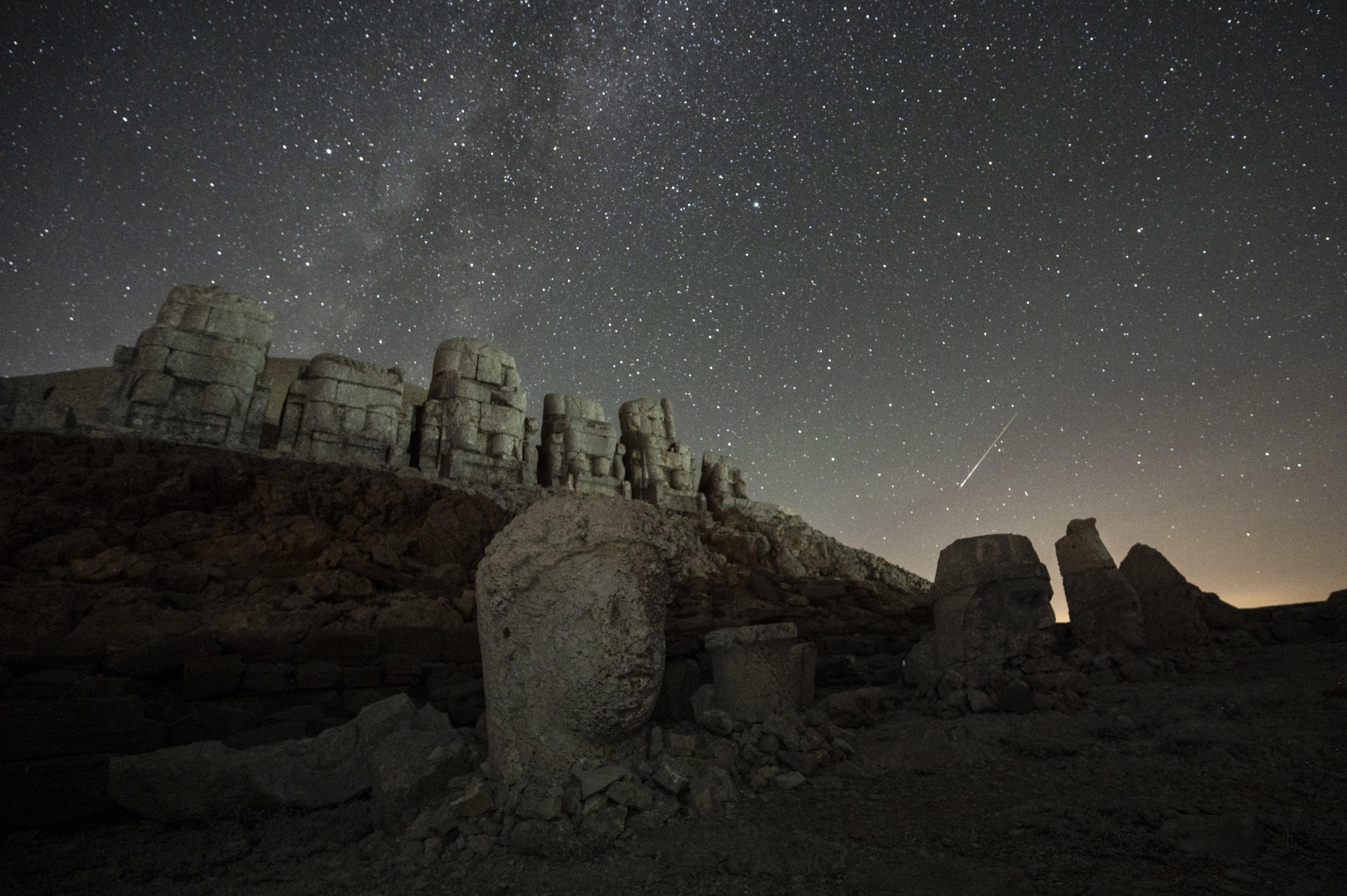 Las cabezas de las enormes esculturas de piedra se pueden ver en el sitio arqueológico del Monte Nimrut en forma de meteorito que atraviesa el cielo nocturno.