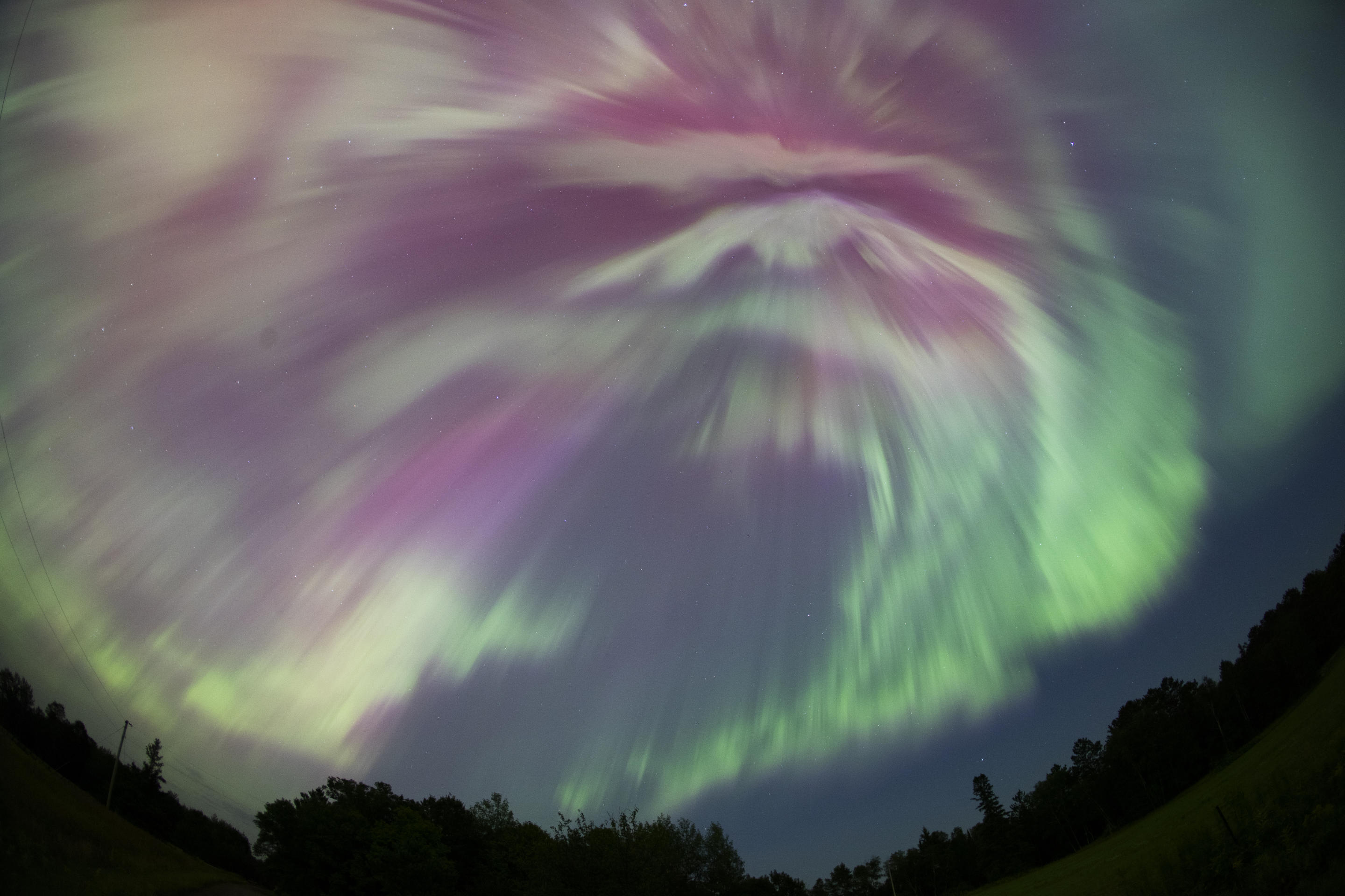 Una tormenta geomagnética produce vibrantes colores verde y rosa durante el pico de la lluvia de meteoritos de las Perseidas en Aitkin, Minnesota.