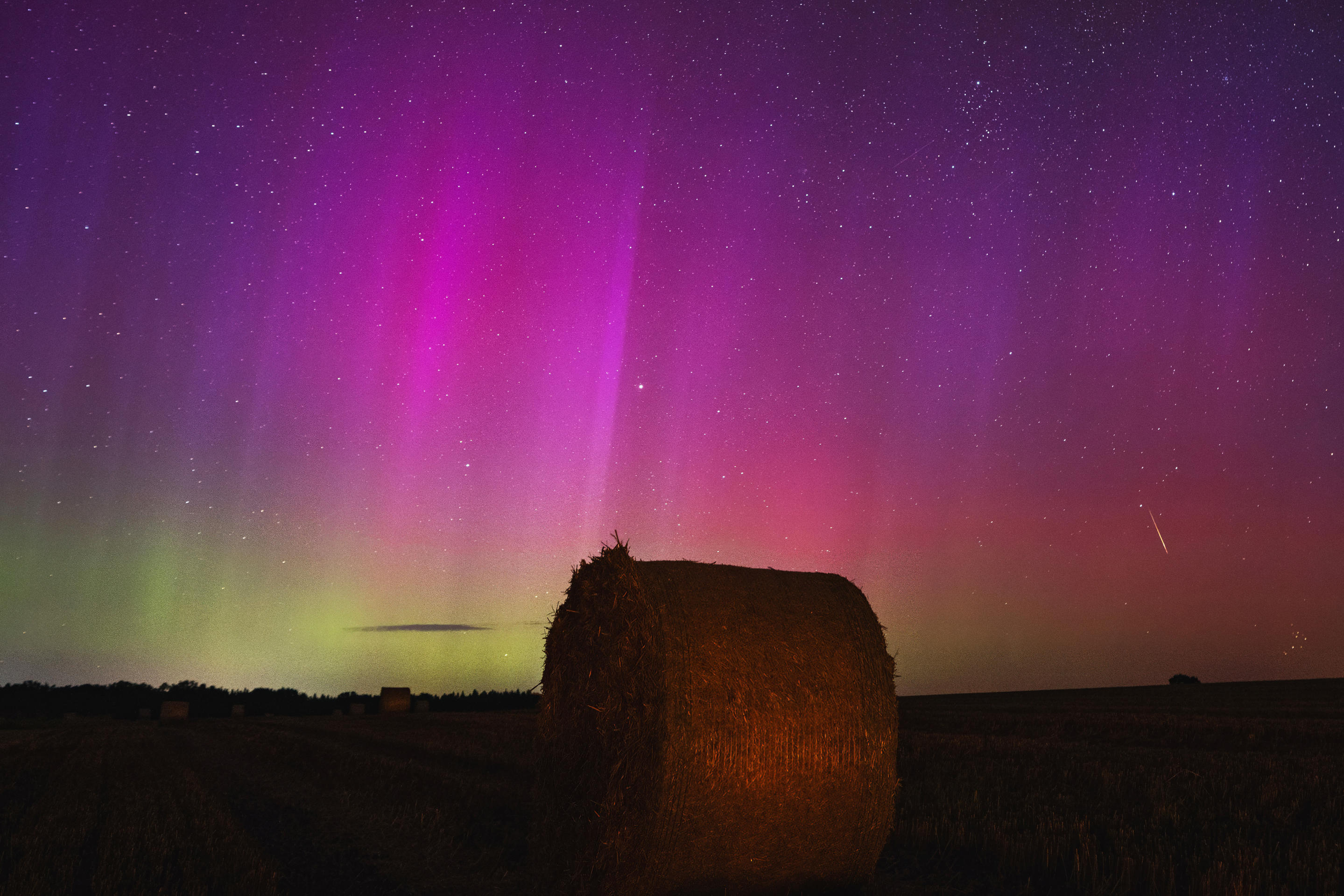 Una deslumbrante exhibición de la aurora boreal sobre un campo de heno en Brandeburgo, Alemania.