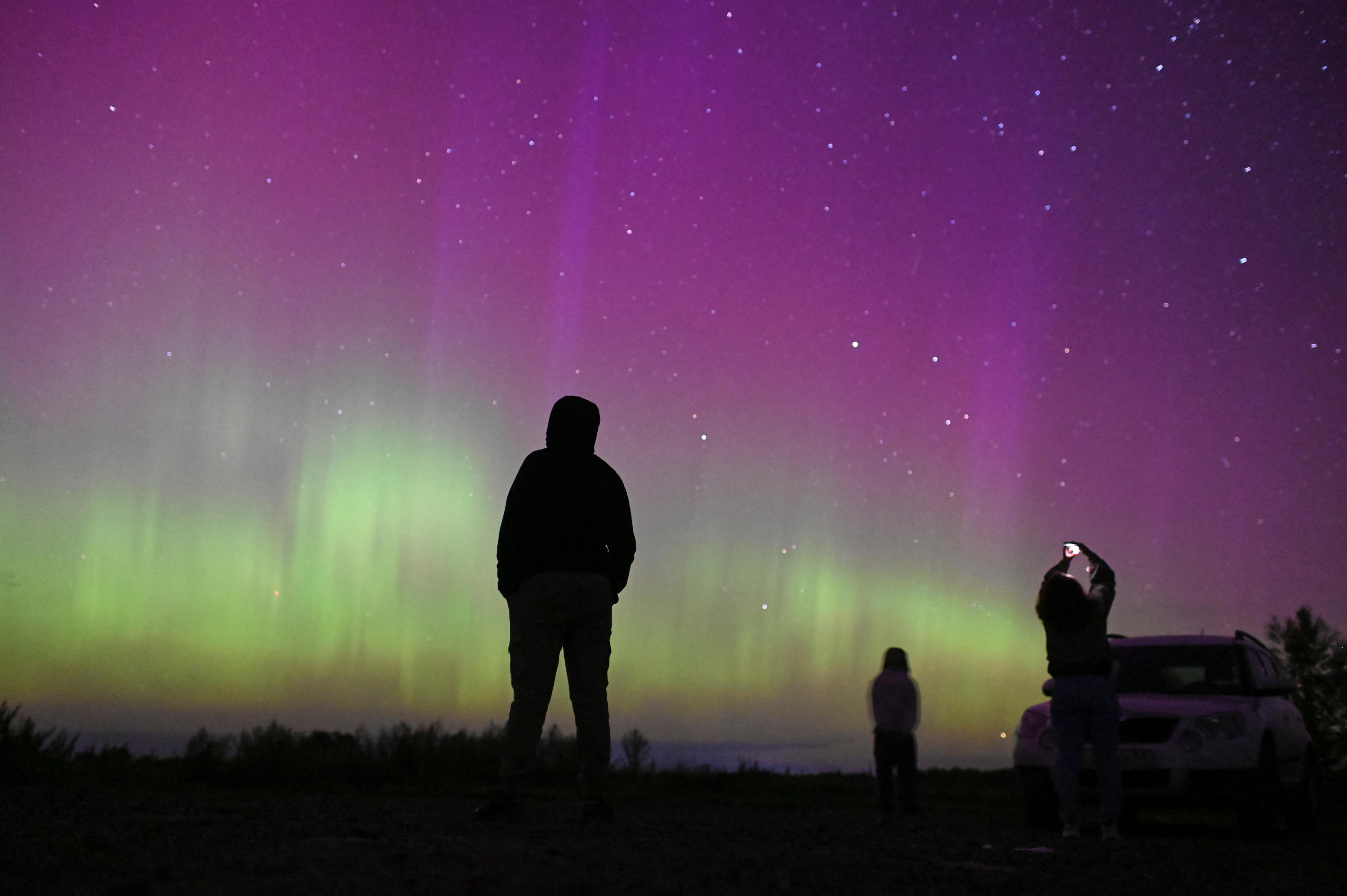 La gente se reúne para observar la espectacular exhibición de la lluvia anual de meteoritos de las Perseidas y la aurora boreal cerca del pueblo de Borodinka en la región rusa de Omsk.