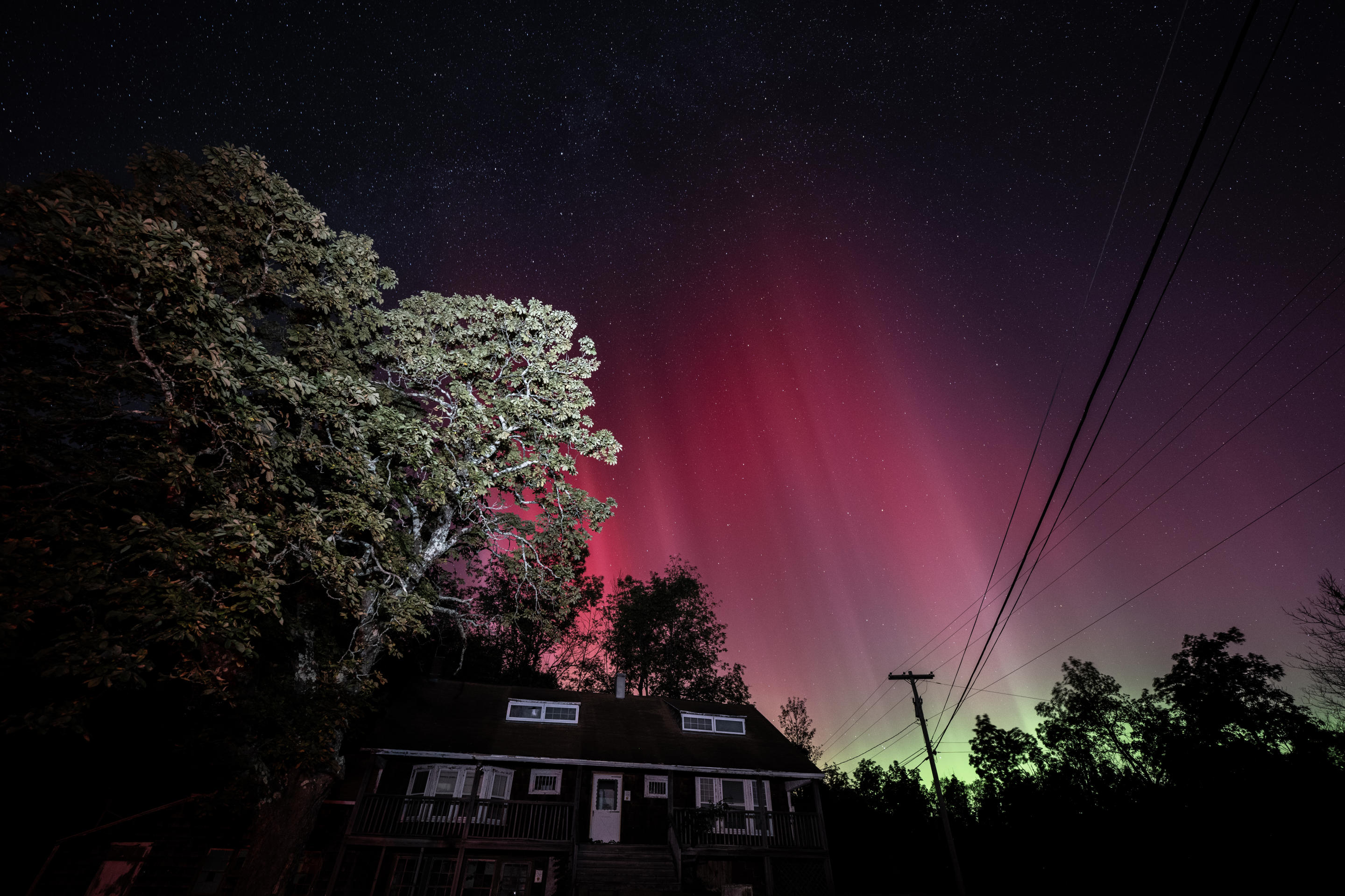 Una rara exhibición de color cuando la aurora boreal ilumina el cielo sobre una casa de Nueva York.