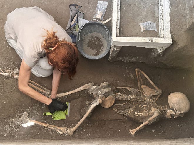 Un arqueólogo trabaja en los restos de una víctima descubierta recientemente en el sitio arqueológico de la antigua ciudad de Pompeya, destruida en el año 79 d.C. por la erupción del Monte Vesubio, en Pompeya, Italia, el 5 de julio de 2024.