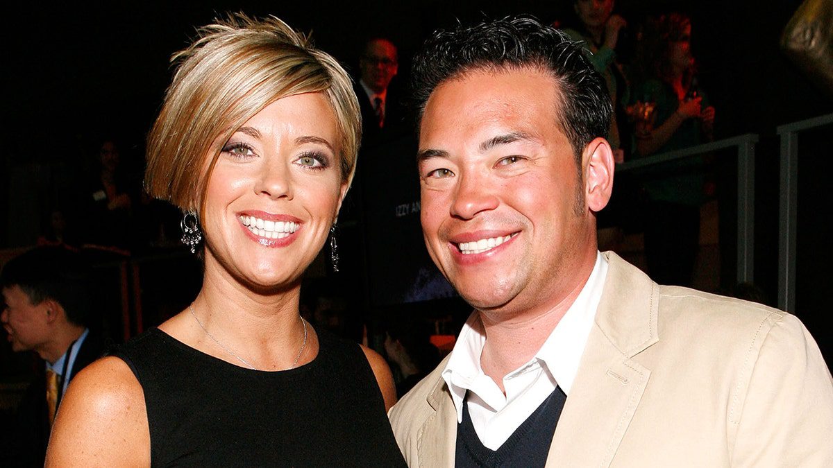 Kate Gosselin lleva un vestido negro con un corte de pelo corto y entrecortado y sonríe junto a Jon Gosselin, que lleva una chaqueta marrón y una chaqueta oscura.