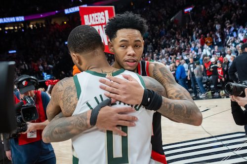 El guardia de los Portland Trail Blazers, Anfernee Simmons, abraza a su ex compañero de equipo y al guardia de los Milwaukee Bucks, Damian Lillard.