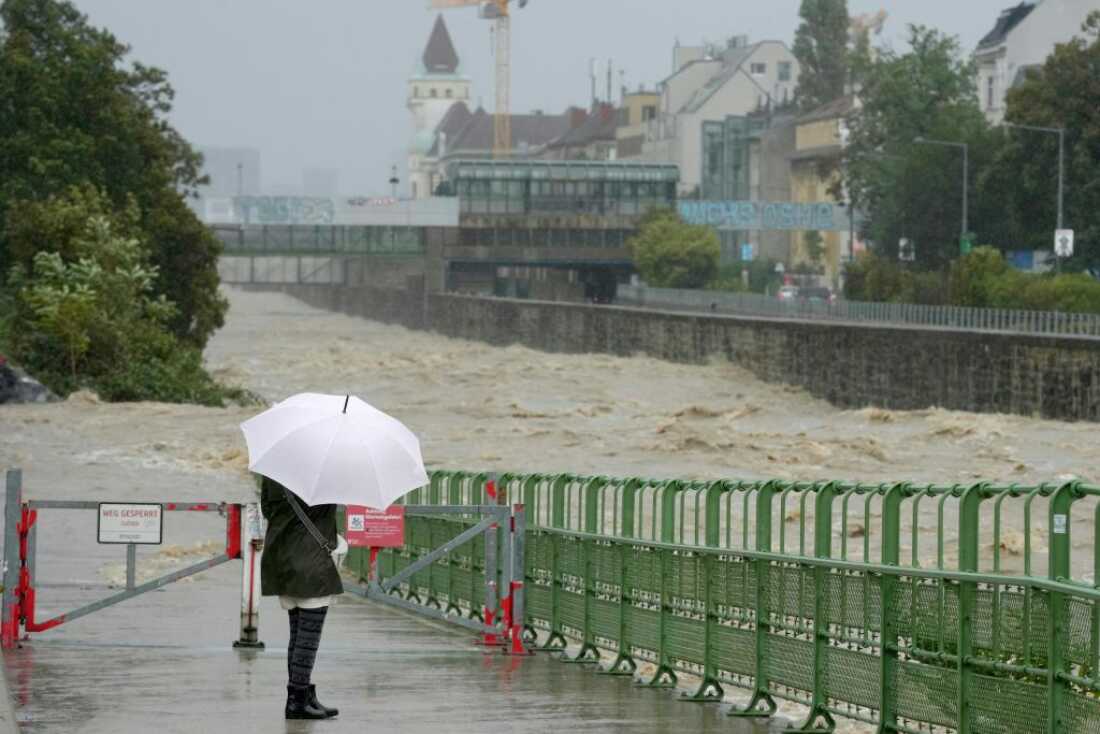 Un peatón observa el aumento del nivel del río Viena en Hoteldorf, Viena, durante una fuerte lluvia el 15 de septiembre de 2024.