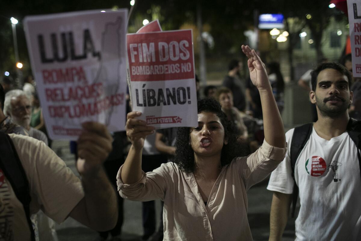 Una mujer sostiene un cartel escrito en portugués. "Poner fin a los bombardeos en el Líbano" durante 