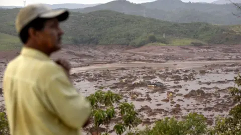 Getty Images Un hombre observa el lugar del colapso de una presa en el pueblo de Pinto Rodrigues, en Marianas, estado de Minas Gerais, en el sureste de Brasil, el 6 de noviembre de 2015.